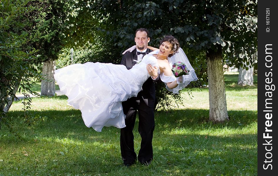 Bride and groom having fun in park