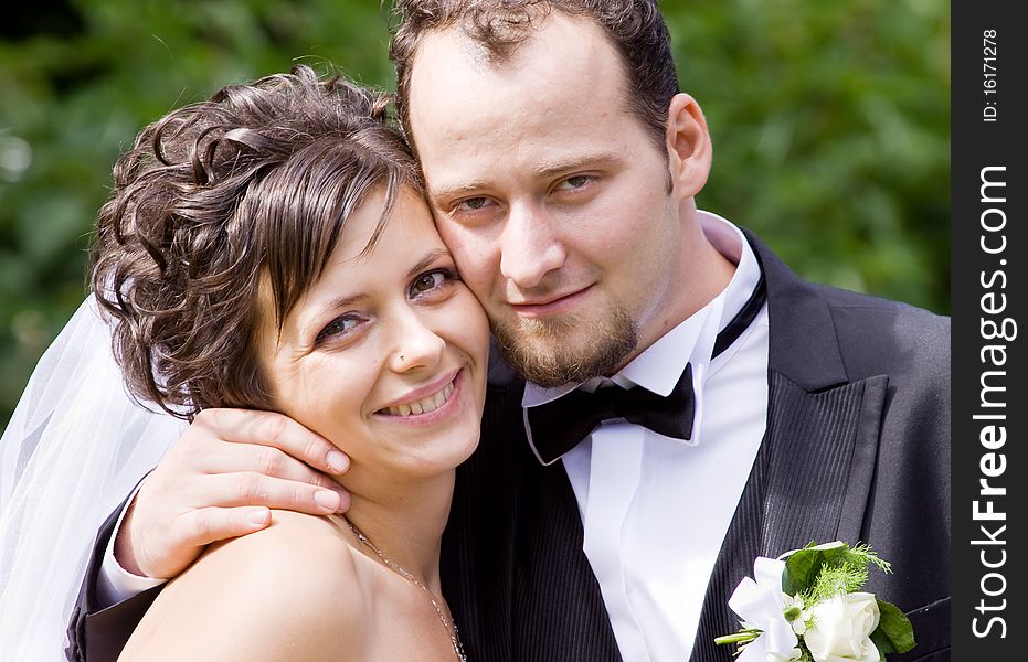 Bride and groom having fun in park