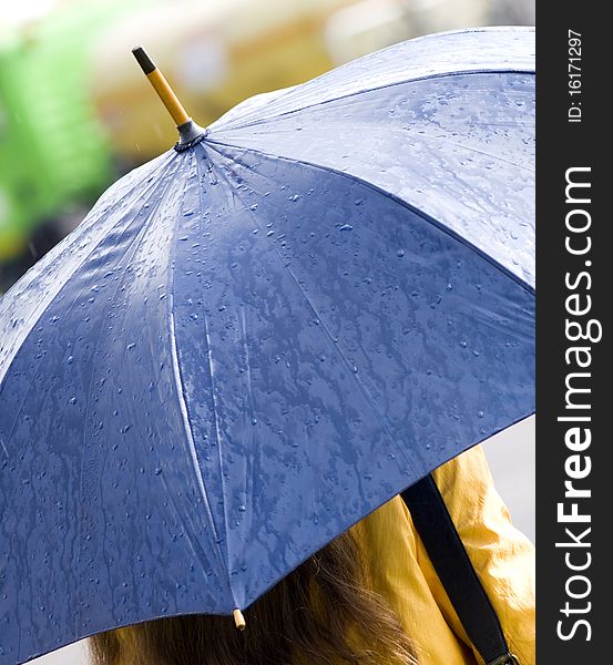Woman with yellow coat and blue umbrella. Woman with yellow coat and blue umbrella