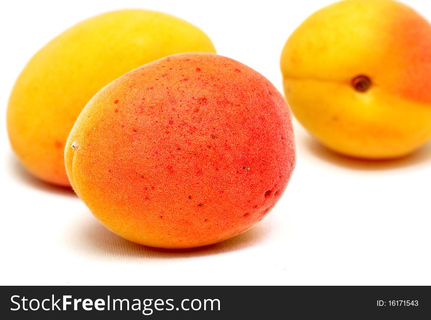 Three apricots isolated over white background