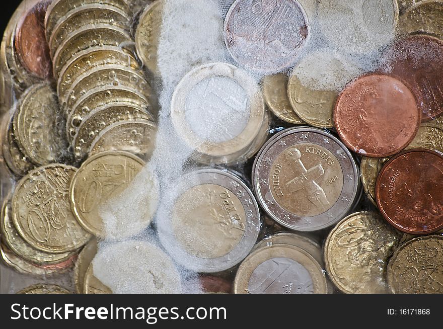 Shiny euro coins frozen in ice