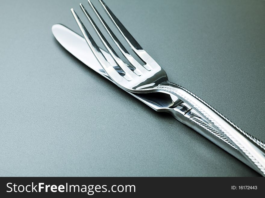 Silver fork, knife and spoon  over grey background. Silver fork, knife and spoon  over grey background.