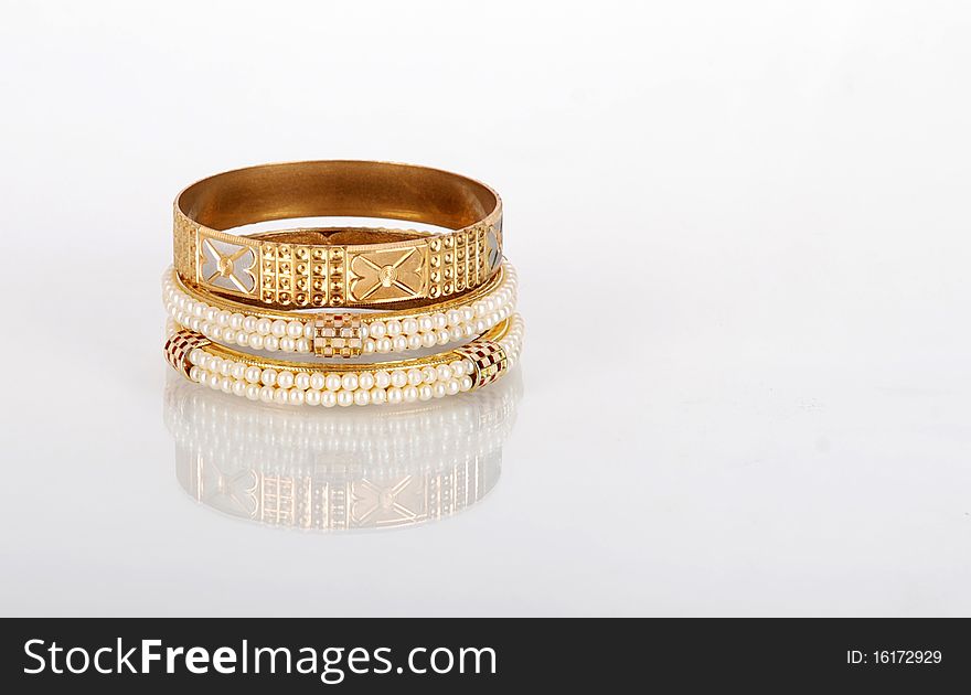 Beautiful golden pearl bangles isolated on white