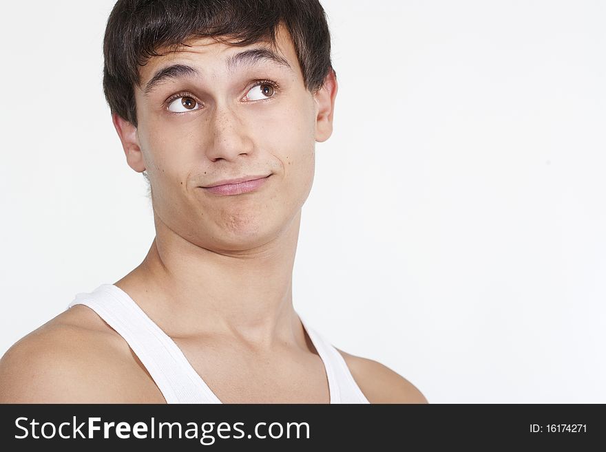 Closeup of a handsome young teenaged guy looking away in thought isolated on white