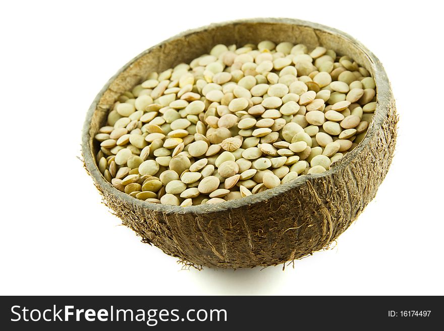 Lentils in a coconut shell bowl isolated on white background