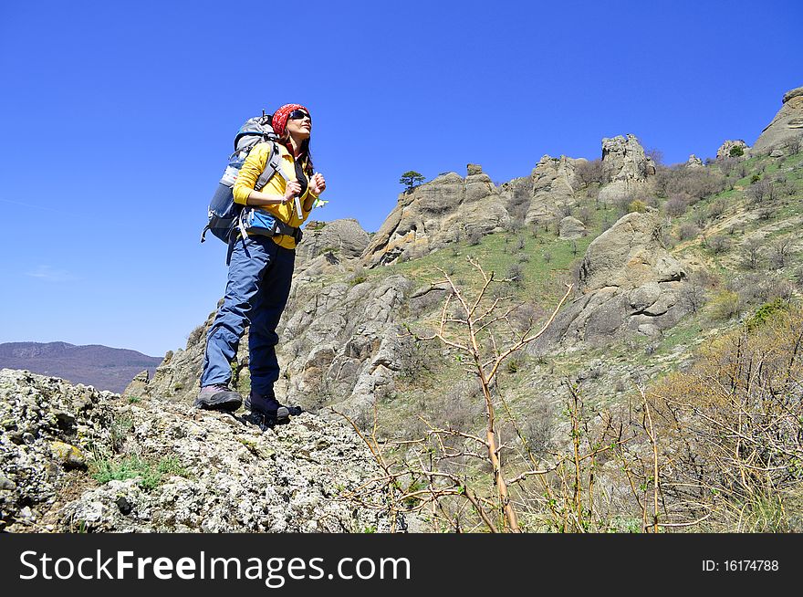 Girl tourist with a backpack on a background of mountains. Girl tourist with a backpack on a background of mountains