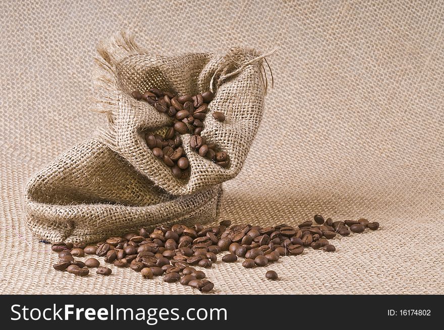 Sack of coffee beans over textured burlap background. Sack of coffee beans over textured burlap background