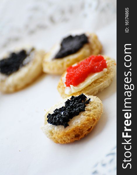 Tartines with caviar on a white plate. Tartines with caviar on a white plate