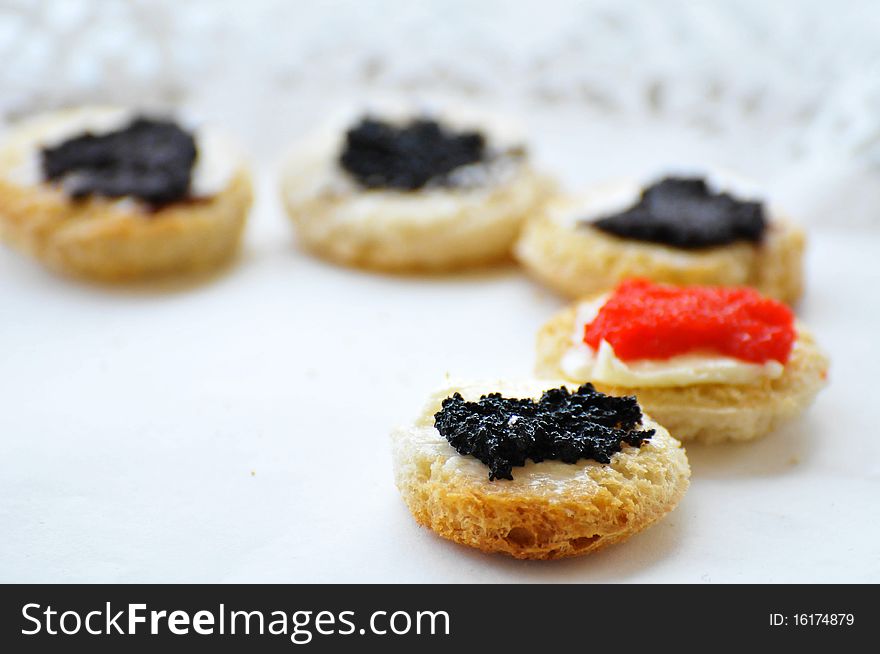 Tartines with caviar on a white plate with shallow depth of field. Tartines with caviar on a white plate with shallow depth of field