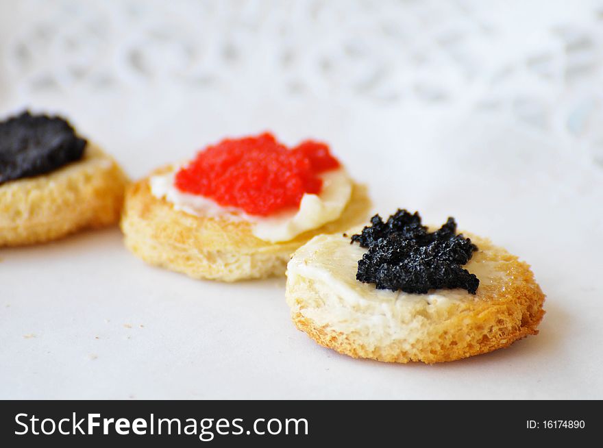 Tartines with caviar on a white plate with shallow depth of field. Tartines with caviar on a white plate with shallow depth of field