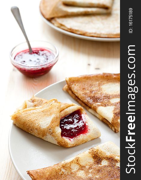 Pancakes with cranberry jam. Stack of pancakes and jam in background. Pancakes with cranberry jam. Stack of pancakes and jam in background