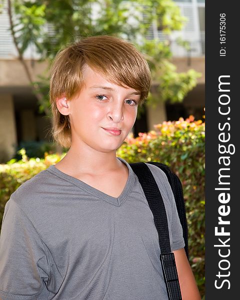 Portrait of young boy standing with a bag . Portrait of young boy standing with a bag .