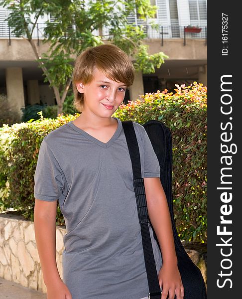 Portrait of a boy with a guitar in a case going to a music school. Portrait of a boy with a guitar in a case going to a music school.