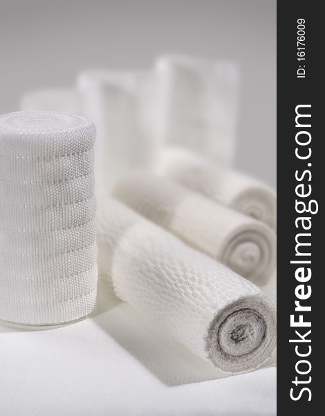 Some rolls of white elastic bandage lie on a table. Some rolls of white elastic bandage lie on a table