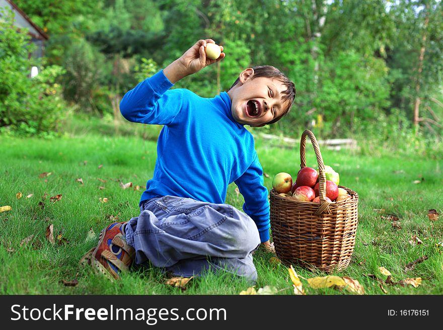 Big harvest - little boy posing outdoors with apples. Big harvest - little boy posing outdoors with apples