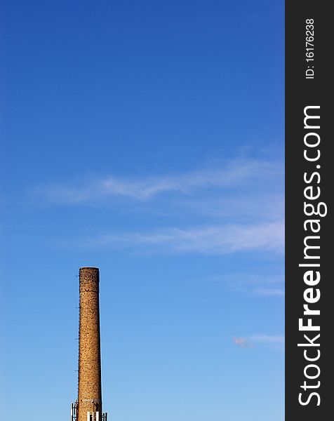 Old brick chimney against blue sky with clouds. Old brick chimney against blue sky with clouds