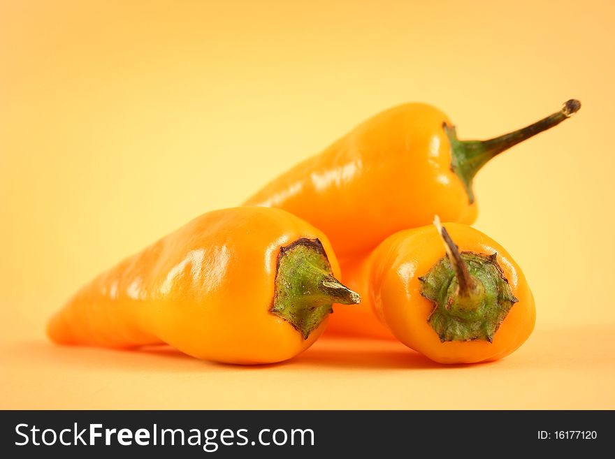 Hot yellow chili peppers on yellow background