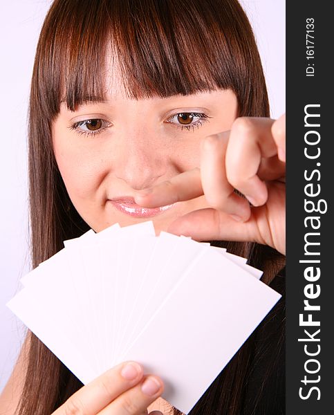 Young woman holding a fan of blank business cards in her hand and choosing one of them. Young woman holding a fan of blank business cards in her hand and choosing one of them