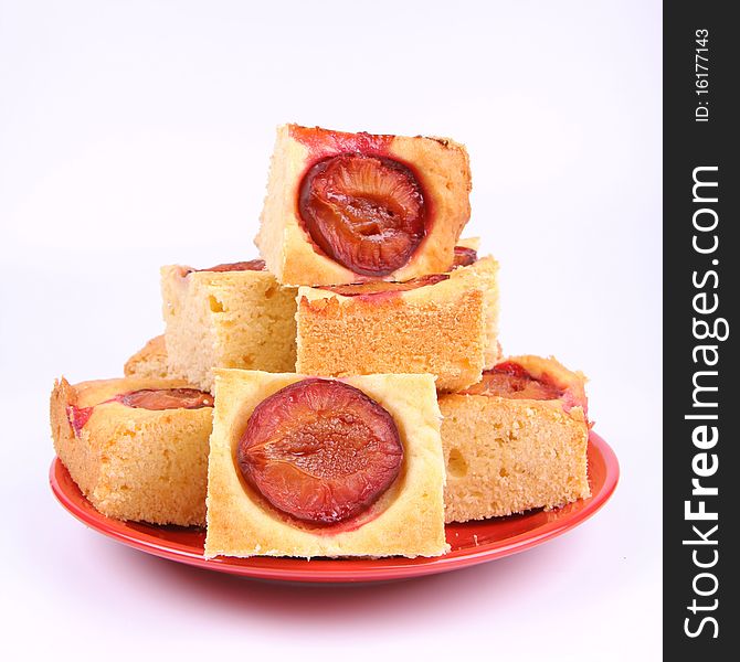 Plum Pie - several portions on a red plate on white background