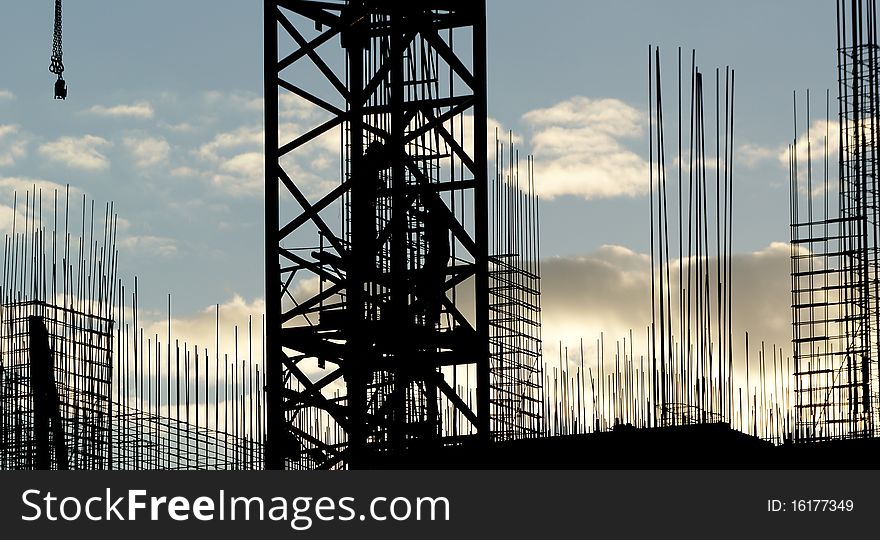 Silhouettes of builders and building structures on the background of a sunset. Silhouettes of builders and building structures on the background of a sunset
