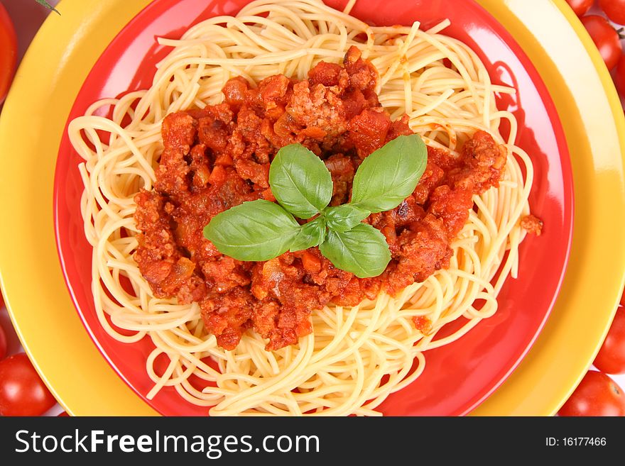 Spaghetti Bolognese on a plate decorated with fresh basil in close up