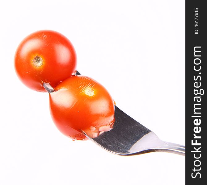 Cherry tomatoes on a fork on white background