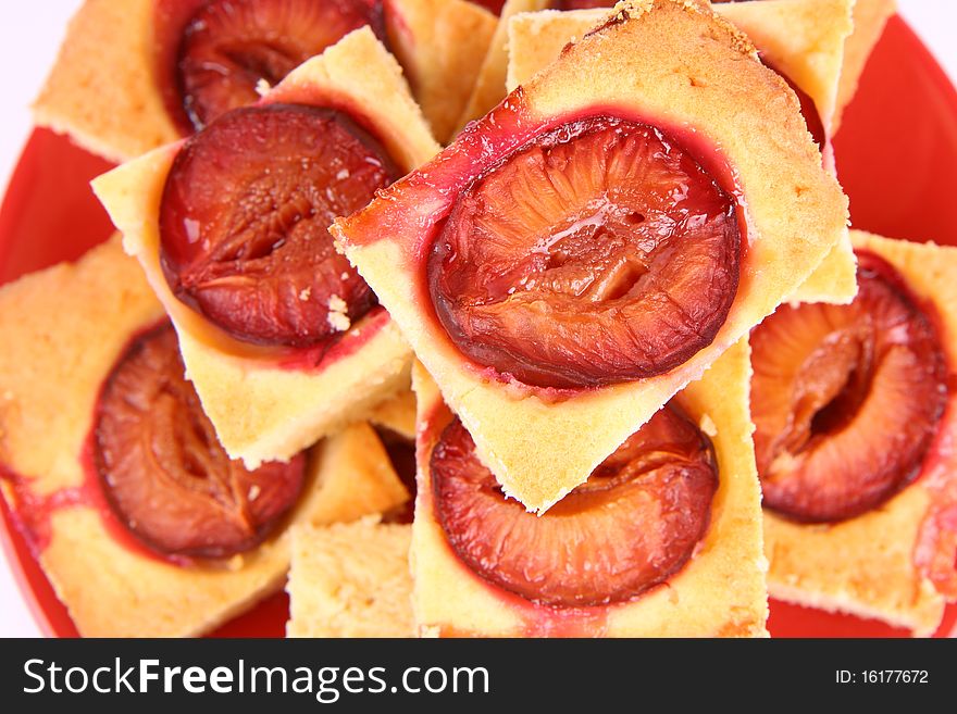 Plum Pie - several portions on a red plate on white background in close up