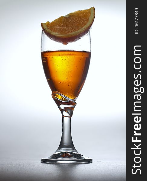 A cut of fresh orange on top of orange effervescent drink. A cut of fresh orange on top of orange effervescent drink.