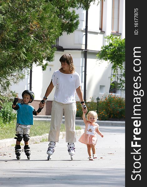 Mother with two children rollerskaing in park