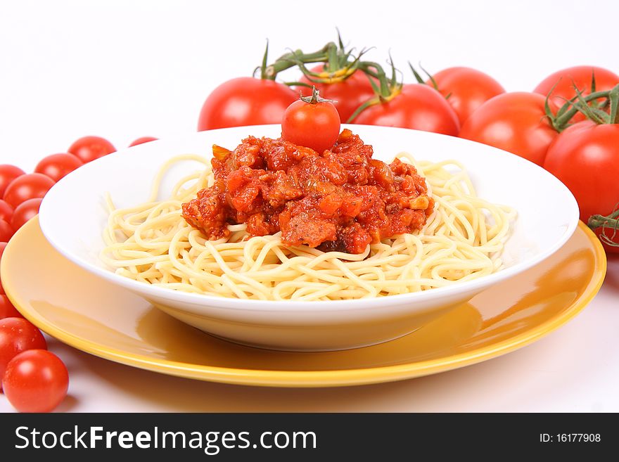 Spaghetti Bolognese on a plate surrounded with tomatoes and cherry tomatoes