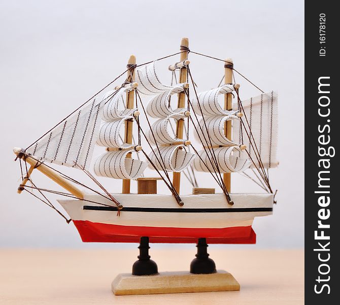 Miniature model of ship on light background