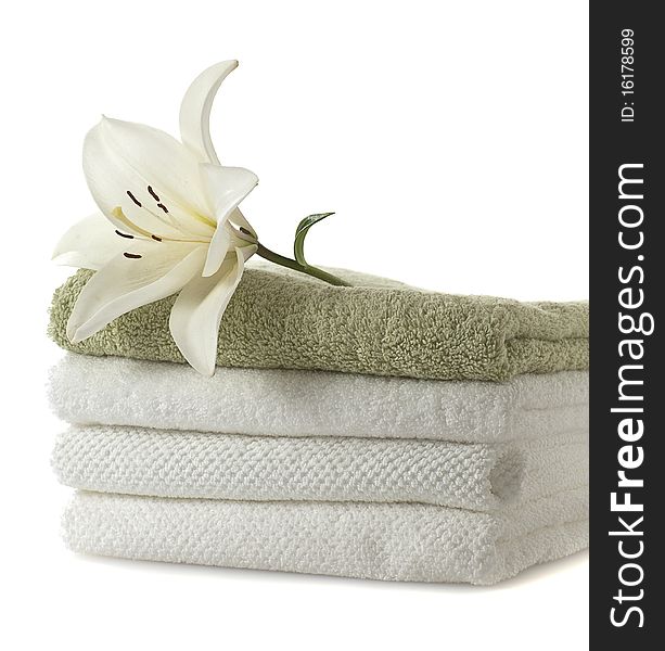 Stack of towels with white lily on white background. Stack of towels with white lily on white background