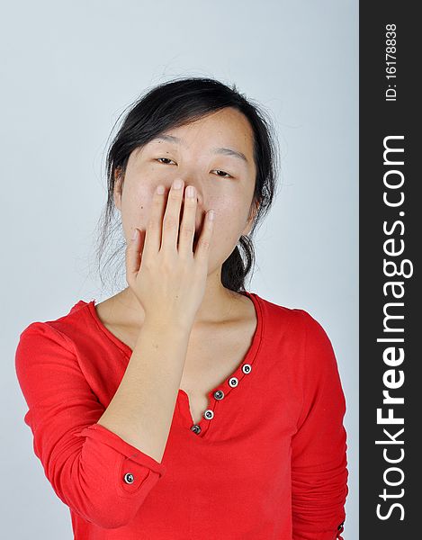 A Chinese girl is yawningï¼ŒShe held her hand blocking the mouth. A Chinese girl is yawningï¼ŒShe held her hand blocking the mouth