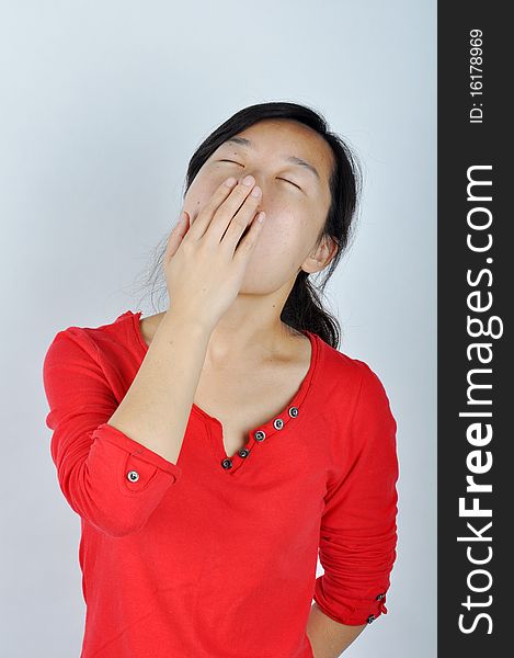 A Chinese girl is yawning，She held her hand blocking the mouth. A Chinese girl is yawning，She held her hand blocking the mouth