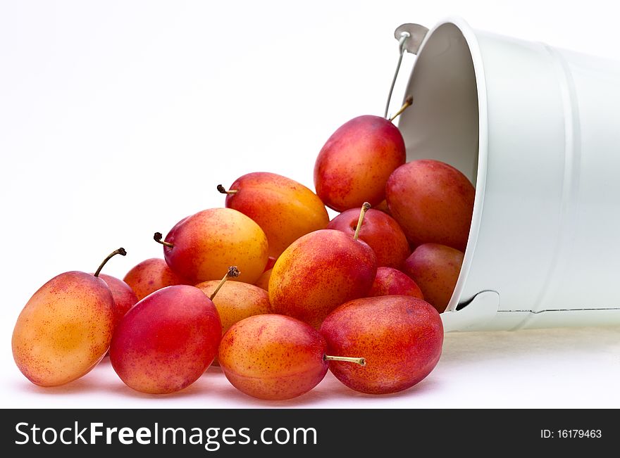 Victoria plums falling from a small pot with a soft shadow. Victoria plums falling from a small pot with a soft shadow