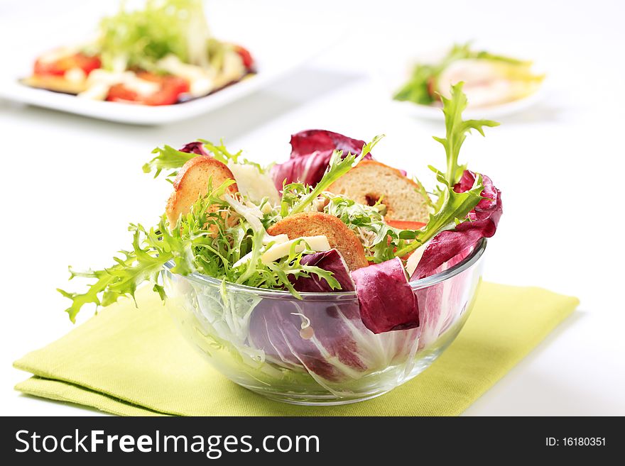 Bowl of green salad with crostini and cheese