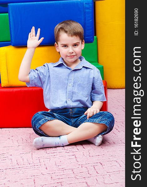 Handsome kid sitting in front of large colorful blocks