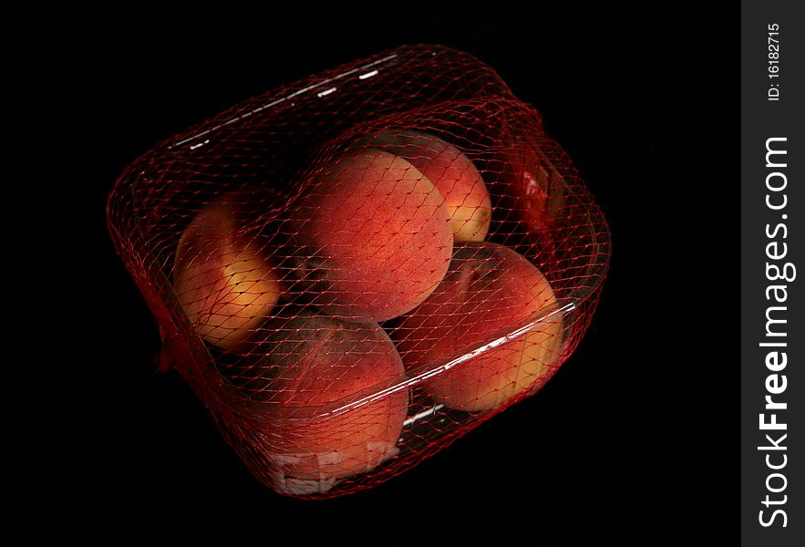 Tub of peaches isolated on black background