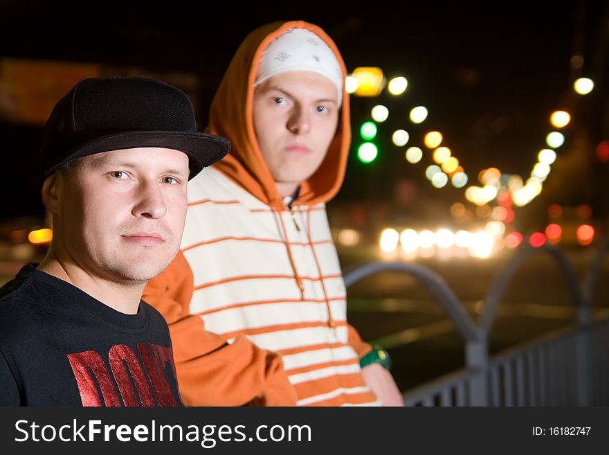 Fashionable young men posing outdoors in the city lights. Fashionable young men posing outdoors in the city lights