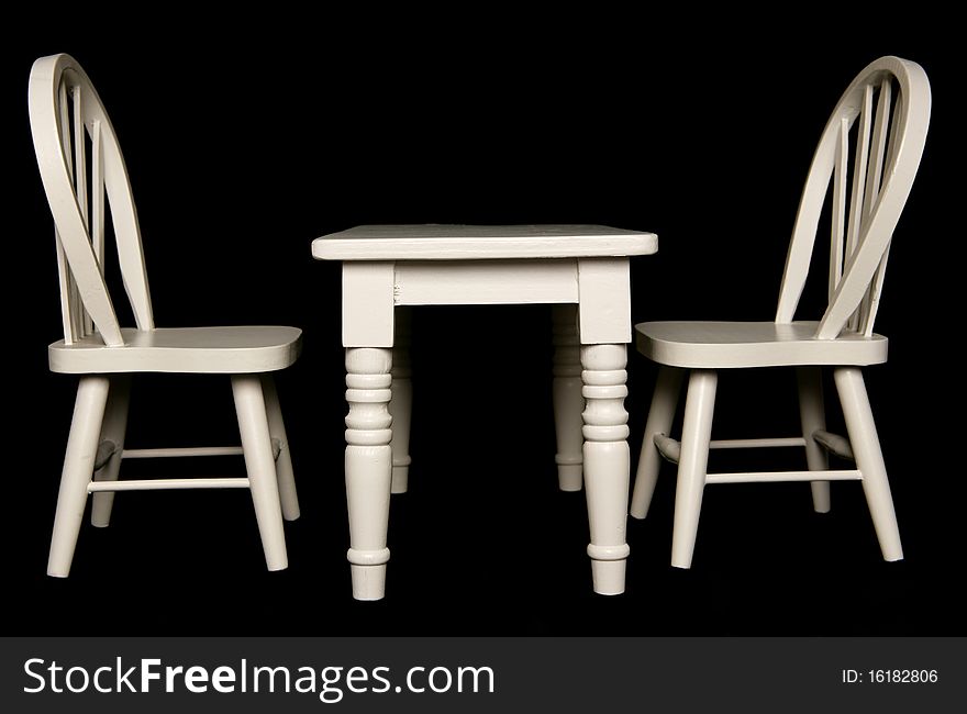 Table and chairs isolated on black background