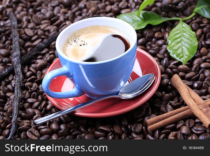 Cup of black coffee on a bed of coffee beans