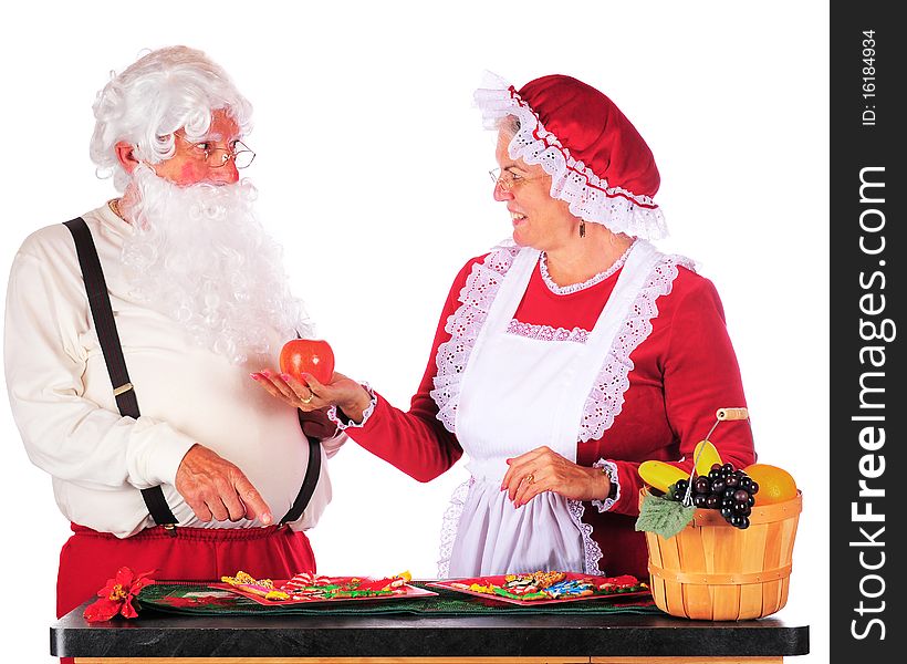 Santa want a cookie, while Mrs. Claus tries to persaude him to eat healthy instead. Isolated on white. Santa want a cookie, while Mrs. Claus tries to persaude him to eat healthy instead. Isolated on white.