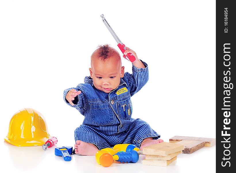 An adorable biracial baby weilding a handsaw while playing with toy tools and wearing craftsman overalls. Isolated on white. An adorable biracial baby weilding a handsaw while playing with toy tools and wearing craftsman overalls. Isolated on white.