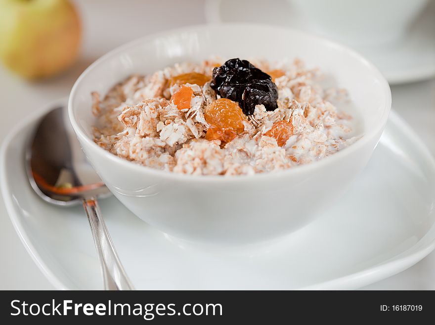 Breakfast: cup of corn flakes, raisins, apricots and milk. Shallow depth of field