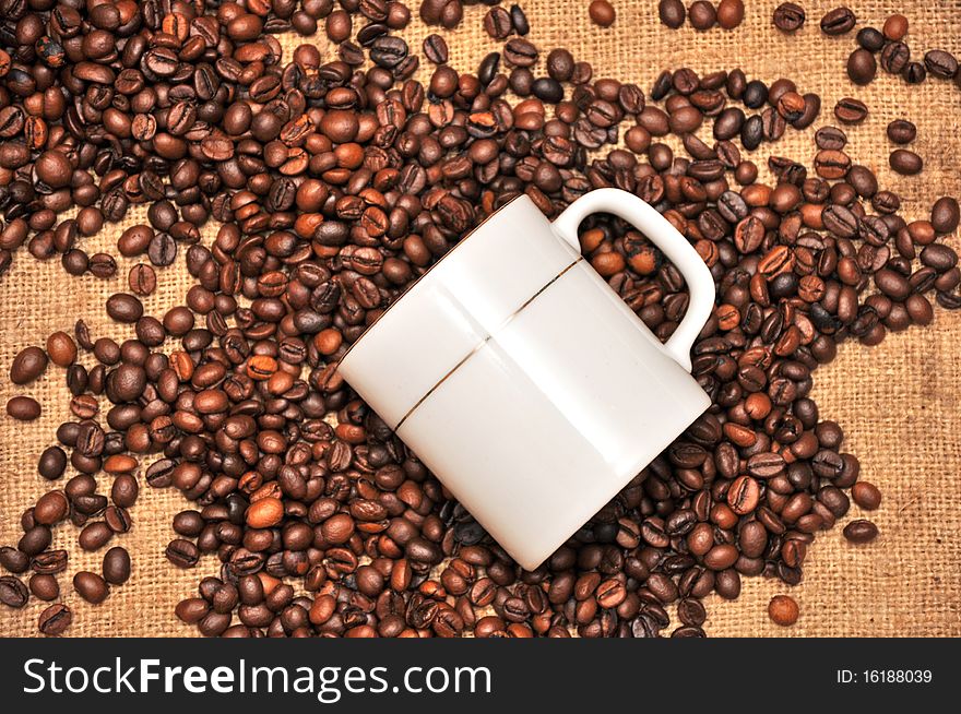Cup of coffee and grain on a background a rough matter. Cup of coffee and grain on a background a rough matter