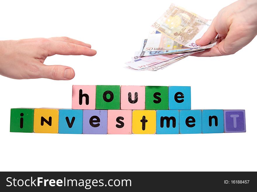 Toy letters that spell house investment with cash in hands against a white background with clipping path. Toy letters that spell house investment with cash in hands against a white background with clipping path