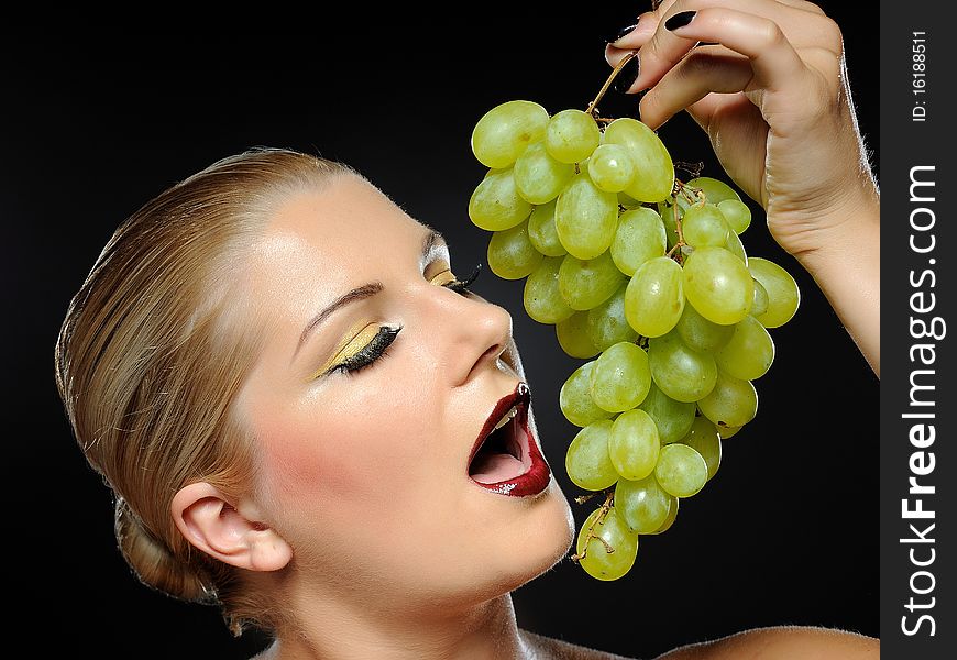 Beautiful woman with bright make-up holding green grapes. Beautiful woman with bright make-up holding green grapes