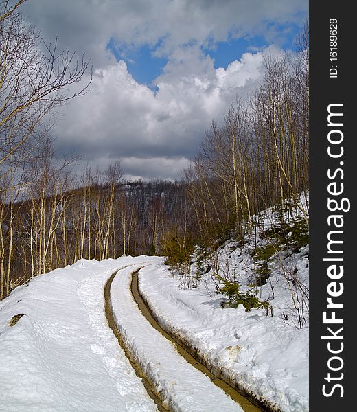 Spring landscape with thawing snow on mountain road