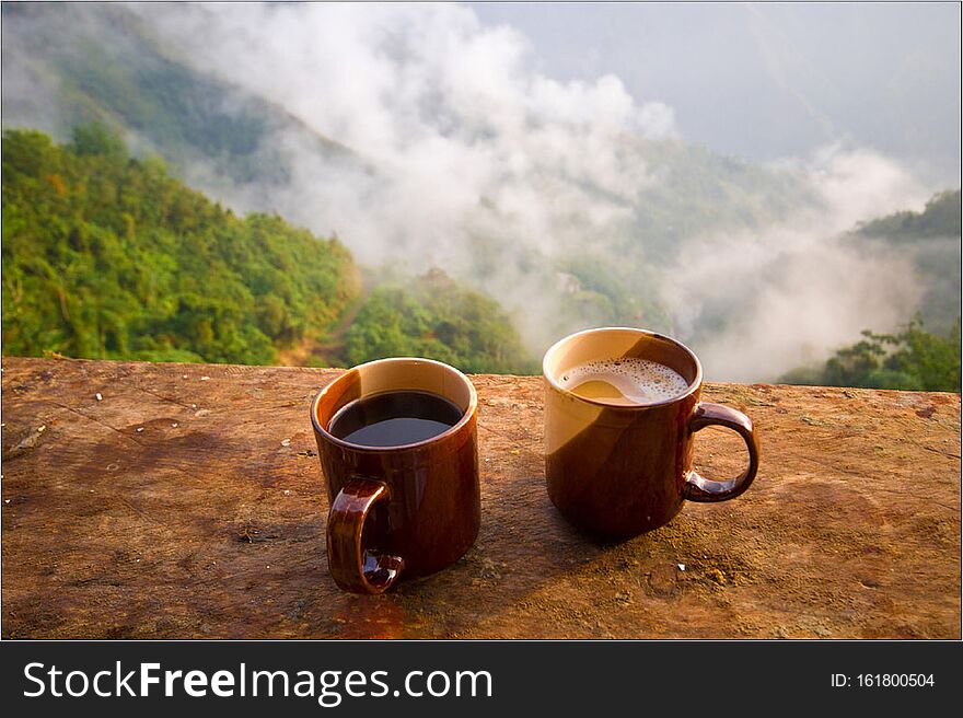 Two cups of hot coffee against a misty sky for a brisk start to the day. Two cups of hot coffee against a misty sky for a brisk start to the day