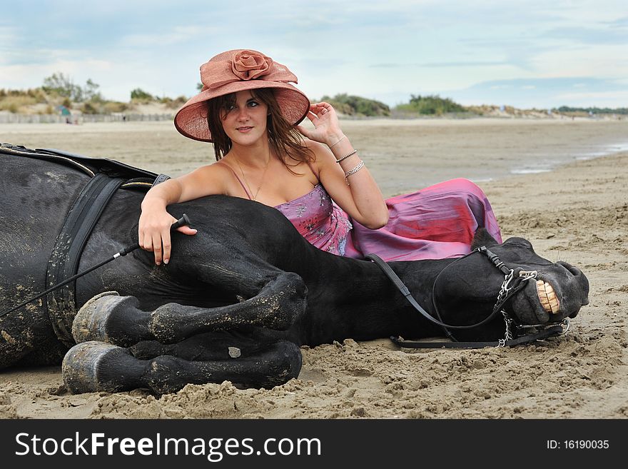 Beautiful black stallion on the beach with young woman. Beautiful black stallion on the beach with young woman